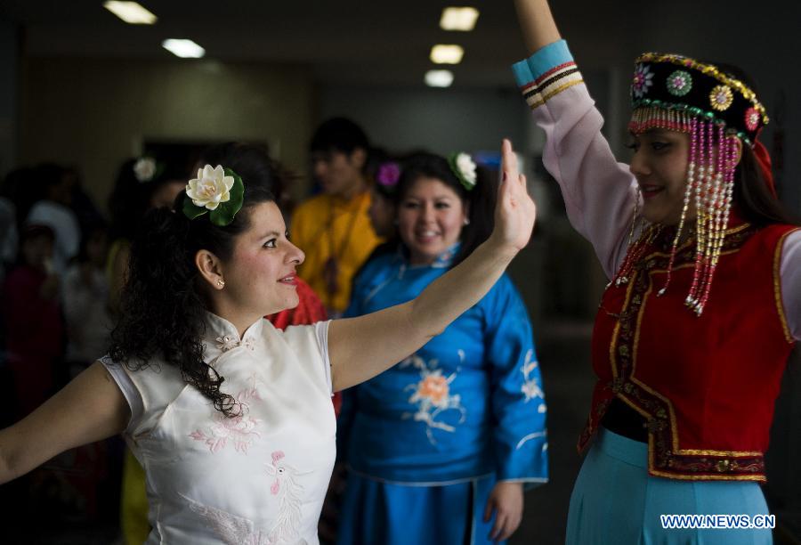Mexican women practise before performances during the Chinese Spring Festival celebration in the City Centre of Mexico City, capital of Mexico, Feb. 9, 2013. (Xinhua/Shi Sisi)     