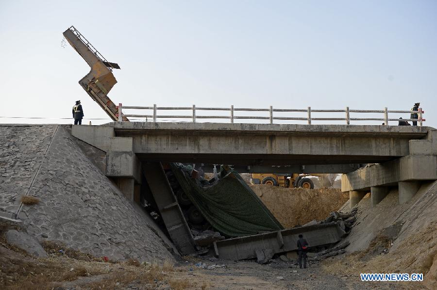 Photo taken on Feb. 10, 2013 shows an outsized casting and its cargo trailer falling down a bridge on No. 304 Provincial Highway, the Shuitao Village, Hongsibao District of Wuzhong City, northwest China's Ningxia Hui Autonomous Region. According to local highway authorities, an overloaded truck carrying the outsized casting, with a gross weight of 100 tons, crushed the bridge with design load of only 55 tons when the truck tried to pass over it. (Xinhua/Wang Peng)