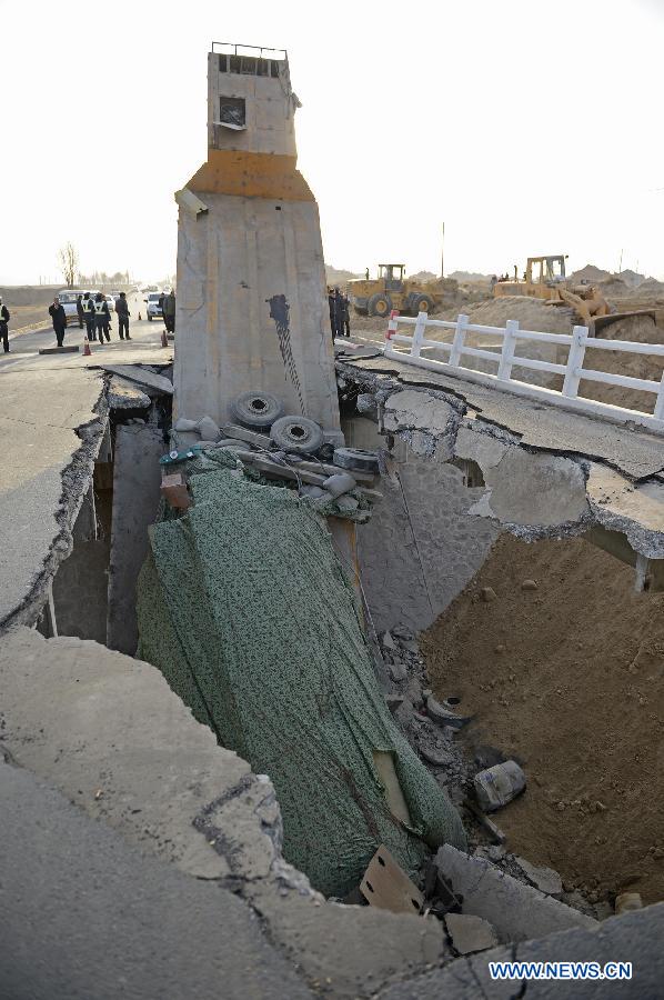 Photo taken on Feb. 10, 2013 shows an outsized casting and its cargo trailer falling down a bridge on No. 304 Provincial Highway, the Shuitao Village, Hongsibao District of Wuzhong City, northwest China's Ningxia Hui Autonomous Region. According to local highway authorities, an overloaded truck carrying the outsized casting, with a gross weight of 100 tons, crushed the bridge with design load of only 55 tons when the truck tried to pass over it. (Xinhua/Wang Peng) 