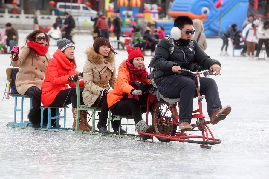 Tourists ride a sled at the Shichahai Lake Ice Rink on the first day of the Chinese Lunar New Year in Beijing, capital of China, Feb. 10, 2013. Many people here chose to spend the first day of the Chinese Lunar New Year on the ice. (Xinhua/Chen Xiaogen) 