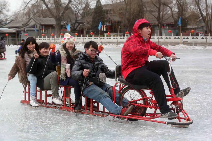 Tourists ride a sled at the Shichahai Lake Ice Rink on the first day of the Chinese Lunar New Year in Beijing, capital of China, Feb. 10, 2013. Many people here chose to spend the first day of the Chinese Lunar New Year on the ice. (Xinhua/Chen Xiaogen)