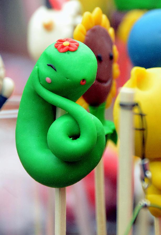 A cute "snake" dough figurine is seen at a temple fair in Zhengzhou, capital of central China's Henan Province, Feb. 10, 2013. Chinese people ushered in the Year of the Snake on Feb. 10 and various snake handicrafts can be seen at temple fairs, a Chinese cultural gathering usually held around the time of the Chinese New Year. (Xinhua/Wang Song)