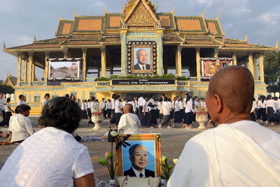 Mourners line up in the distance behind offerings for Cambodia's late King Norodom Sihanouk, whose coffin has been placed in a crematorium, near the Royal Palace in Phnom Penh February 3, 2013. (Xinhua/AFP Photo)