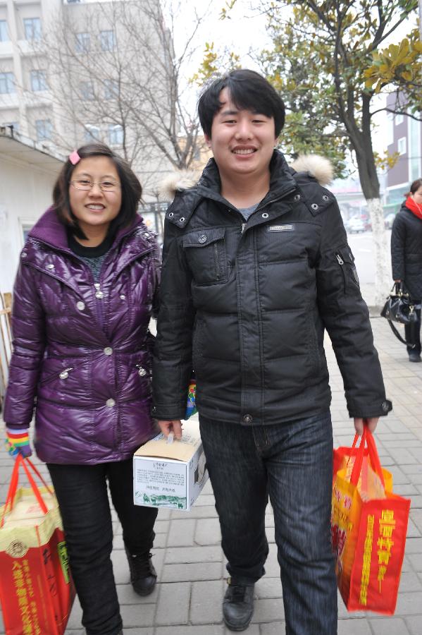 A couple carry presents to visit the wife's family in Hefei, capital of east China's Anhui Province, Feb. 11, 2013. It is the second day of this year's Lunar New Year, or Spring Festival, on Feb. 11, when Chinese married women usually follow a tradition to visit parents with their husbands. (Xinhua/Yang Xiaoyuan)