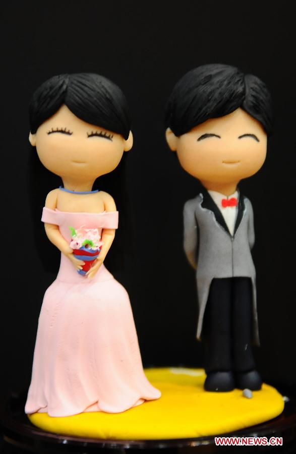 Photo taken on Feb. 12, 2013 shows dough figurines of a couple made by Dou Fengling, a folk artist, in Liaocheng City, east China's Shandong Province. The figurines, as miniatures of couples in love, are popular these days as the Valentine's Day approaches. (Xinhua/Zhang Zhenxiang)