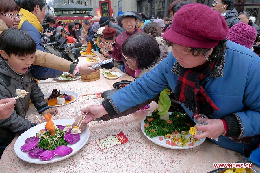 Visitors taste dishes at a banquet in Hangzhou, capital of east China's Zhejiang Province, Feb. 12, 2013. To celebrate the Spring Festival, or the Chinese Lunar New Year, some restaurants in Hangzhou offered free dishes to visitors for taste. (Xinhua/Shi Jianxue)