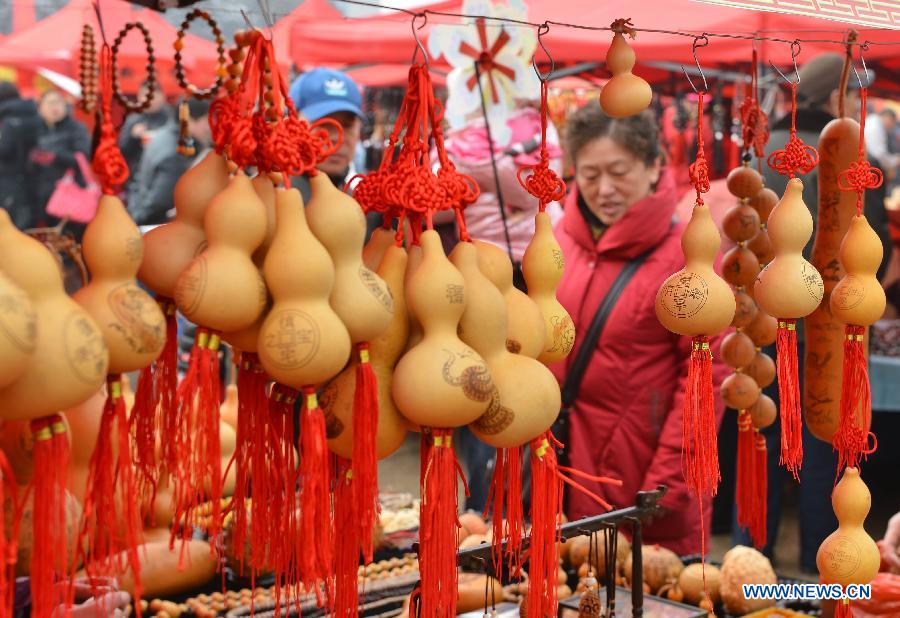 Visitors select handicrafts at a temple fair held to celebrate the Spring Festival, or the Chinese Lunar New Year, in Jinan, capital of east China's Shandong Province, Feb. 12, 2013. (Xinhua/Zhu Zheng)