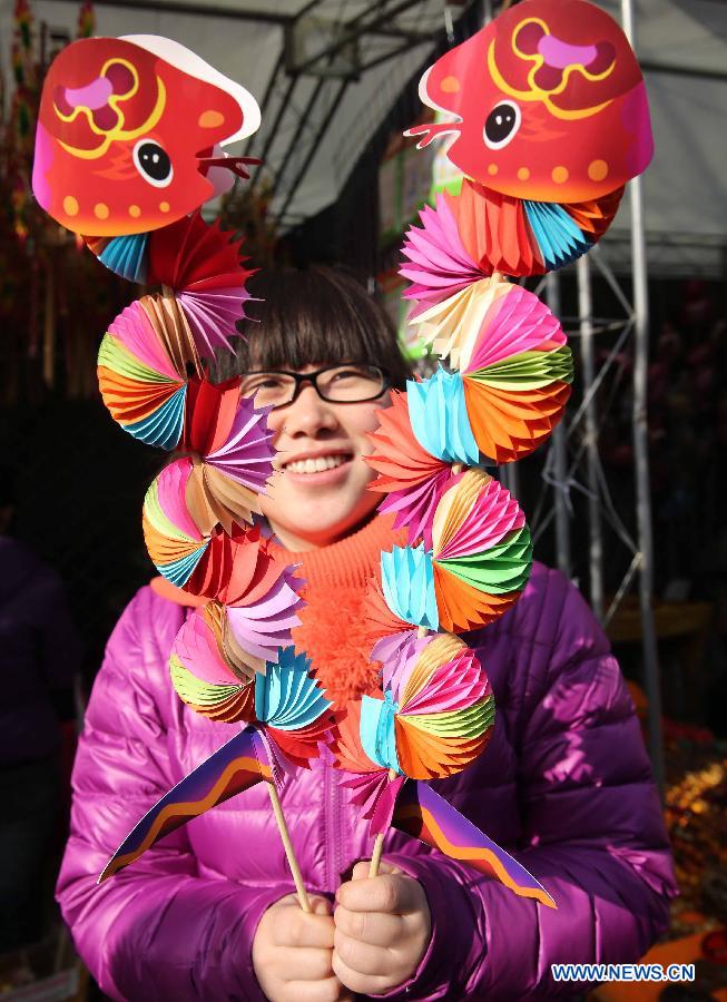 A seller shows the paper-made toys in shape of snakes at a temple fair held to celebrate the Spring Festival, or the Chinese Lunar New Year, in Beijing, capital of China, Feb. 12, 2013. (Xinhua/Chen Xiaogen)