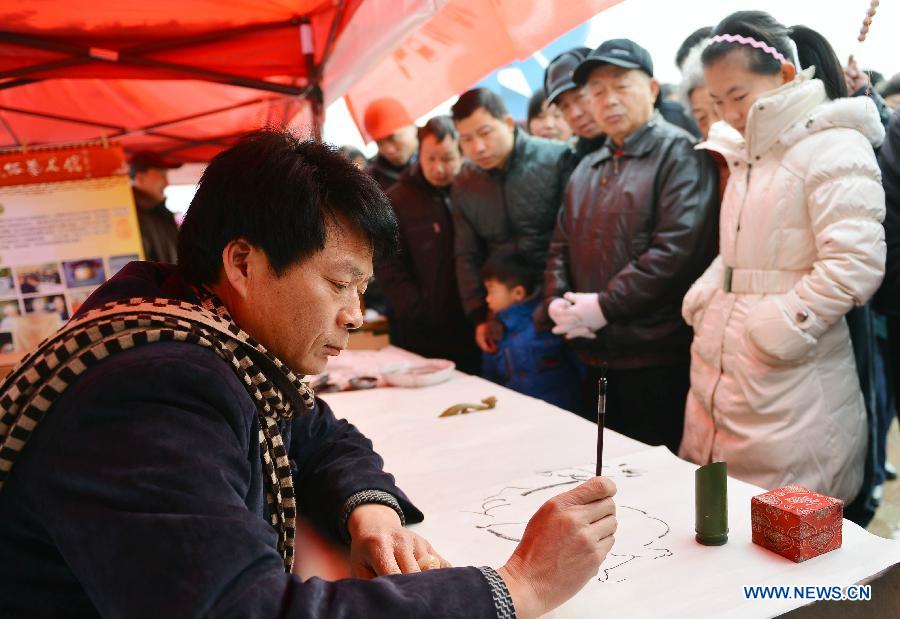 Li Chengjun (L), a painter, draws for visitors at a temple fair held to celebrate the Spring Festival, or the Chinese Lunar New Year, in Jinan, capital of east China's Shandong Province, Feb. 12, 2013. (Xinhua/Zhu Zheng)