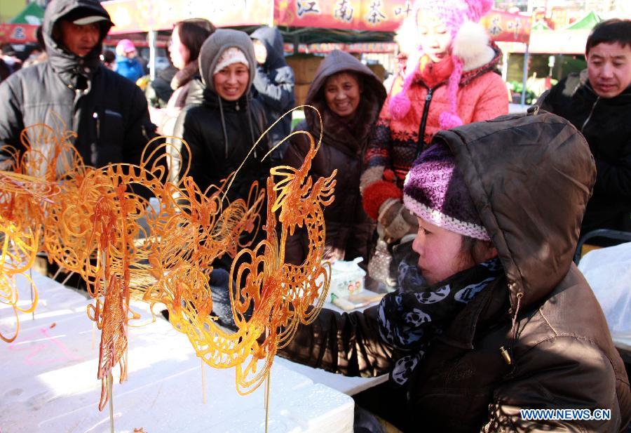An artist performs the "sugar drawing" during a temple fair held to celebrate the Spring Festival, or the Chinese Lunar New Year, in Shenyang, capital of northeast China's Liaoning Province, Feb. 10, 2013. (Xinhua/Huang Jinkun)