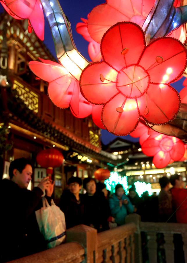 Tourists enjoy lanterns at the Yuyuan Garden in Shanghai, east China, Feb. 11, 2013. Lantern show in the garden attracted many citizens. (Xinhua/Liu Ying) 