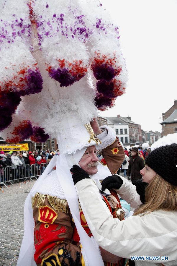 A Gille wears a huge hat made of white ostrich feathers during the Binche Carnival in Binche, Belgium, Feb. 12, 2013. Binche Carnival was inscribed on the Representative List of the Intangible Cultural Heritage of Humanity by UNESCO in 2003. (Xinhua/Wang Xiaojun)