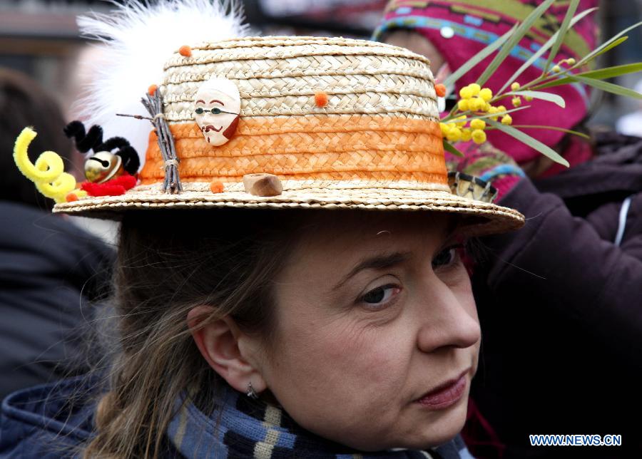 A reveller wearing a hat with Binche mask decorations is seen during the Binche Carnival in Binche, Belgium, Feb. 12, 2013. Binche Carnival was inscribed on the Representative List of the Intangible Cultural Heritage of Humanity by UNESCO in 2003. (Xinhua/Wang Xiaojun) 