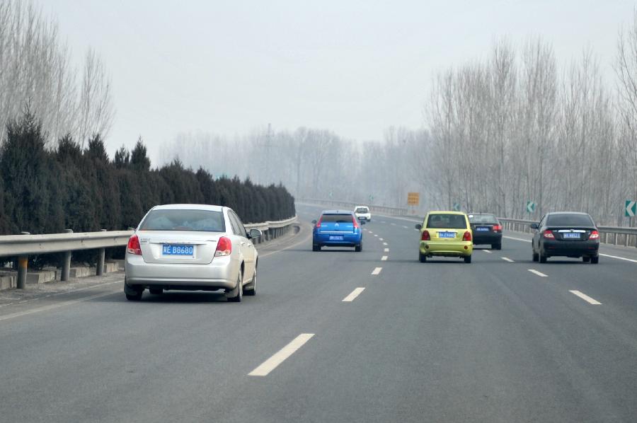 Vehicles run on the G5 Express Way connecting Beijing to southwest China's Kunming City in Baoding of north China's Hebei Province, Feb. 13, 2013. Travel peak emerged in multiple express ways in China as people started the return trips to their workplaces prior to the end of the Spring Festival holiday. (Xinhua/Zhu Xudong)