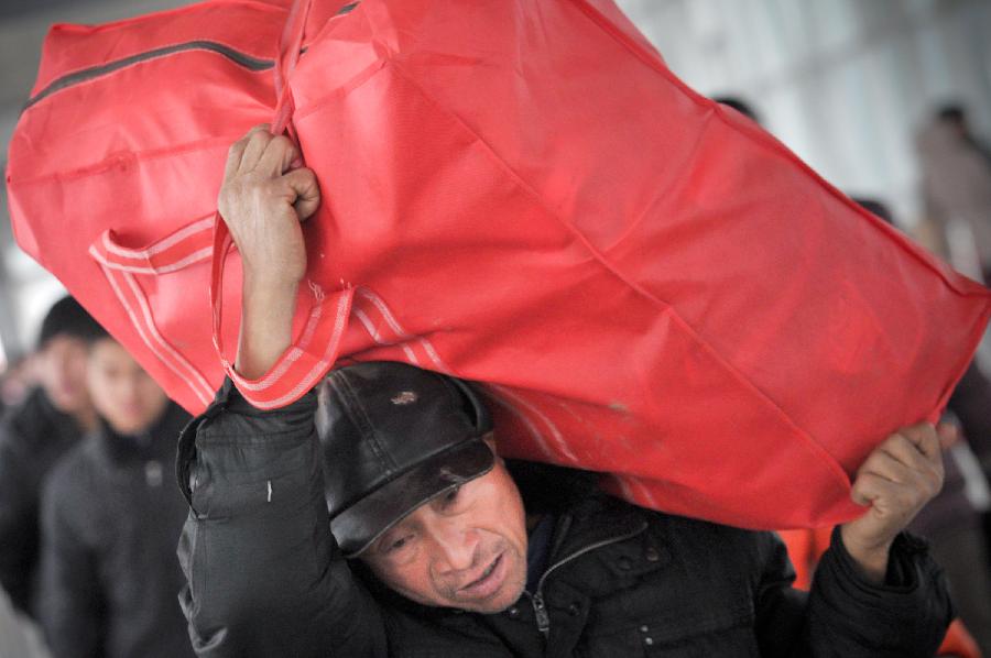 A man carries his bag walking on the platform in a train station in Fuyang of east China's Anhui Province, Feb. 13, 2013. Some people in China started the return trips to their workplaces as the Spring Festival holiday coming to its conclusion. (Xinhua/Guo Chen) 