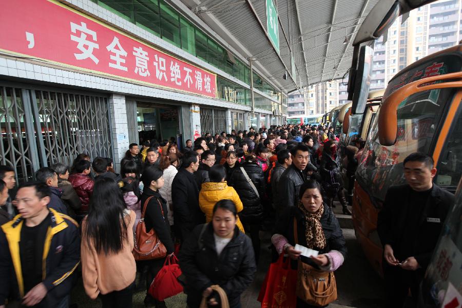 Passengers move to board coaches at a long-distance coach station in Renshou County, Meishan City, southwest China's Sichuan Province, Feb. 13, 2013. The number of road passengers rises as half of the week-long Spring Festival holiday has passed, and many people are returning to their jobs from home-reunions. (Xinhua/Yao Yongliang)