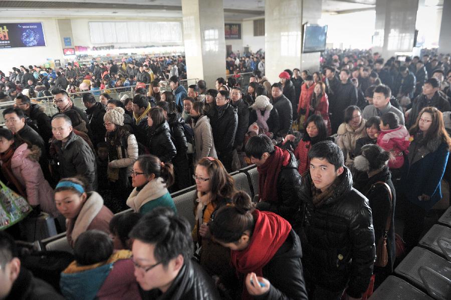 Passengers wait in the hall of a train station in Fuyang of east China's Anhui Province, Feb. 13, 2013. Some people in China started the return trips to their workplaces as the Spring Festival holiday coming to its conclusion. (Xinhua/Guo Chen) 