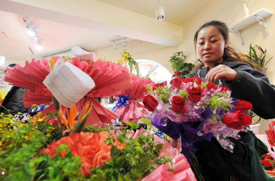 A woman works on a bunch of roses in a flower shop in Yinchuan, capital of northwest China's Ningxia Hui Autonomous Region, Feb. 13, 2013. Florists in Yinchuan began their preparation of bouquets for the upcoming Valentine's Day. (Xinhua/Peng Zhaozhi) 