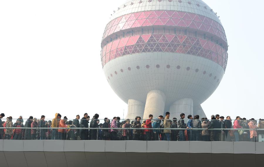 People visit the Lujiazui Financial District in Shanghai, east China, Feb. 10, 2013. People in China are enjoying the week-long holiday of Spring Festival, or Chinese Lunar New Year. Numerous travelers has crammed in tourism sites across the country. (Xinhua/Lai Xinlin) 