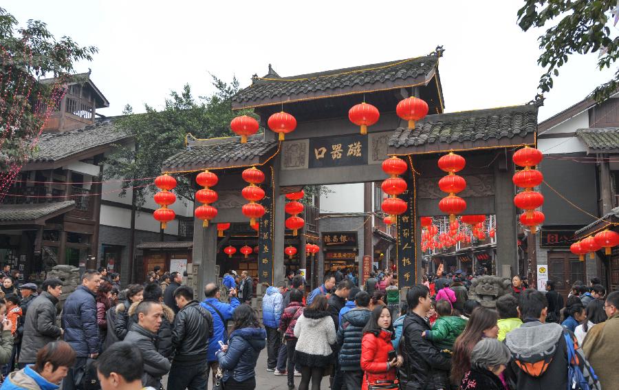 Tourists are seen on a street of the Ciqikou Town in southwest China's Chongqing Municipality, Feb. 13, 2013. Large amount of tourists visited the time-honored Ciqikou during the Spring Festival holiday. (Xinhua/Liu Chan) 