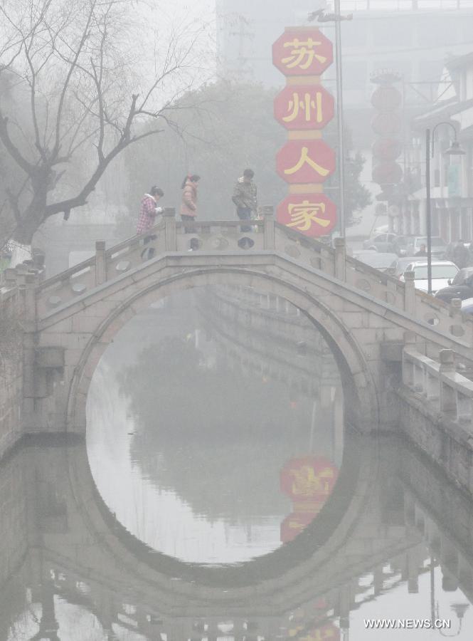 Citizens walk on a fog-shrouded bridge in Suzhou, east China's Jiangsu Province, Feb. 14, 2013. A heavy fog hit Jiangsu on Feb. 14, affecting the traffic. (Xinhua/Wang Jiankang) 