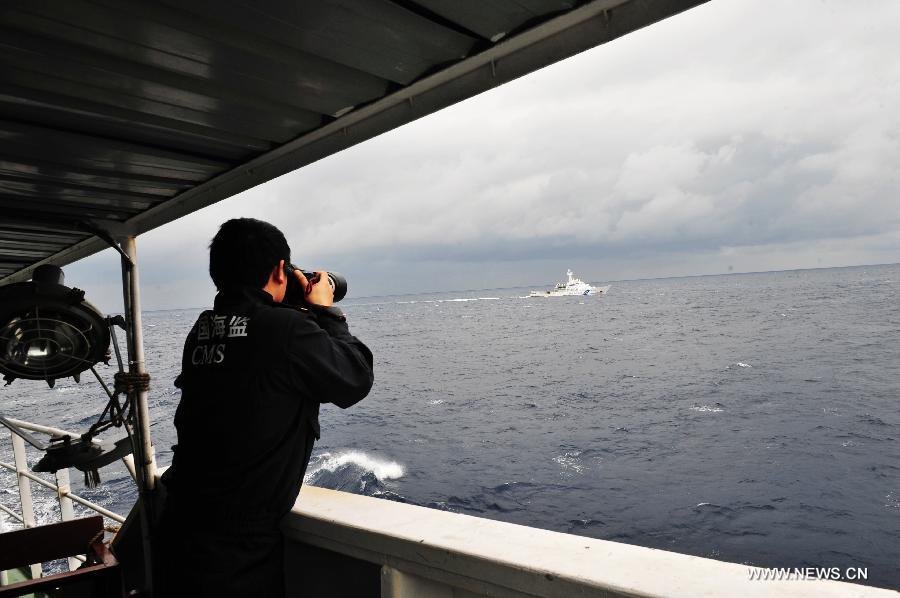 An officer of the China Maritime Surveillance collects evidence of Japanese ships aboard the Chinese marine surveillance ship Haijian 137 during its regular patrol in waters surrounding the Diaoyu Islands on Feb. 14, 2013. The fleet of Chinese marine surveillance ships continued regular patrol surrounding the Diaoyu Islands during the Spring Festival holiday. (Xinhua/Zhang Jiansong) 