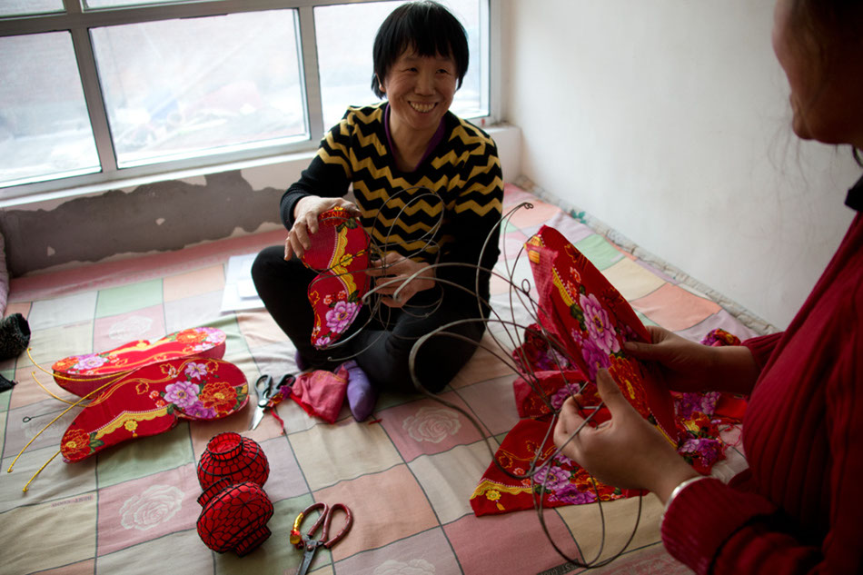 Zhou Zhihong, a 46-year-old woman, makes small lanterns at home in Hongmiao. Local farmers work at home during the busy season.