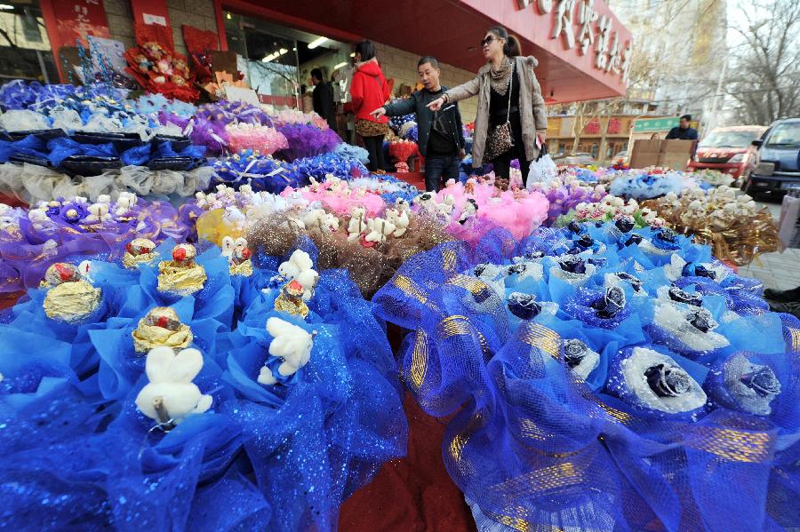 Customers select bouquets outside a flower shop in Yinchuan, capital of northwest China's Ningxia Hui Autonomous Region, Feb. 13, 2013. Florists in Yinchuan began their preparation of bouquets for the upcoming Valentine's Day. [Xinhua/Peng Zhaozhi]