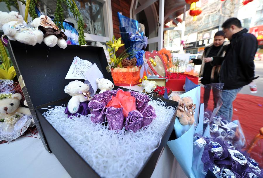 Bouquets decorated with dolls are seen outside a flower shop in Yinchuan, capital of northwest China's Ningxia Hui Autonomous Region, Feb. 13, 2013. Florists in Yinchuan began their preparation of bouquets for the upcoming Valentine's Day. [Xinhua/Peng Zhaozhi]