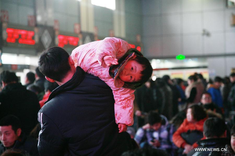 A man carries his child at Nantong Coach Station in Nantong, east China's Jiangsu Province, Feb. 15, 2013. Many children travel with their families during the Spring Festival travel rush. The Spring Festival holiday came to an end on Friday. (Xinhua/Cui Genyuan) 