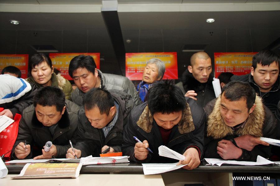 People fill their personal information at a job fair in Liaocheng, east China's Shandong Province, Feb. 15, 2013. As the Spring Festival holiday draws to a close, various job hunting fairs are held among cities across the country. (Xinhua/Kong Xiaozheng)