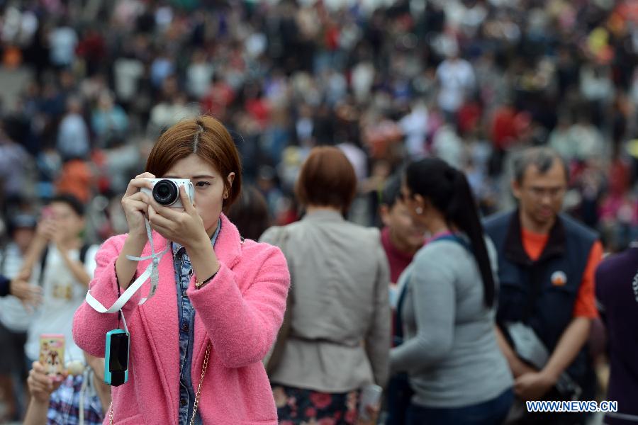A woman takes photos during the Spring Festival holidays in Macao, south China, Feb. 14, 2013. According to the statistics, the totoal number of people entering and exiting all ports of Macao reached 257,000 Thursday. (Xinhua/Cheong Kam Ka) 