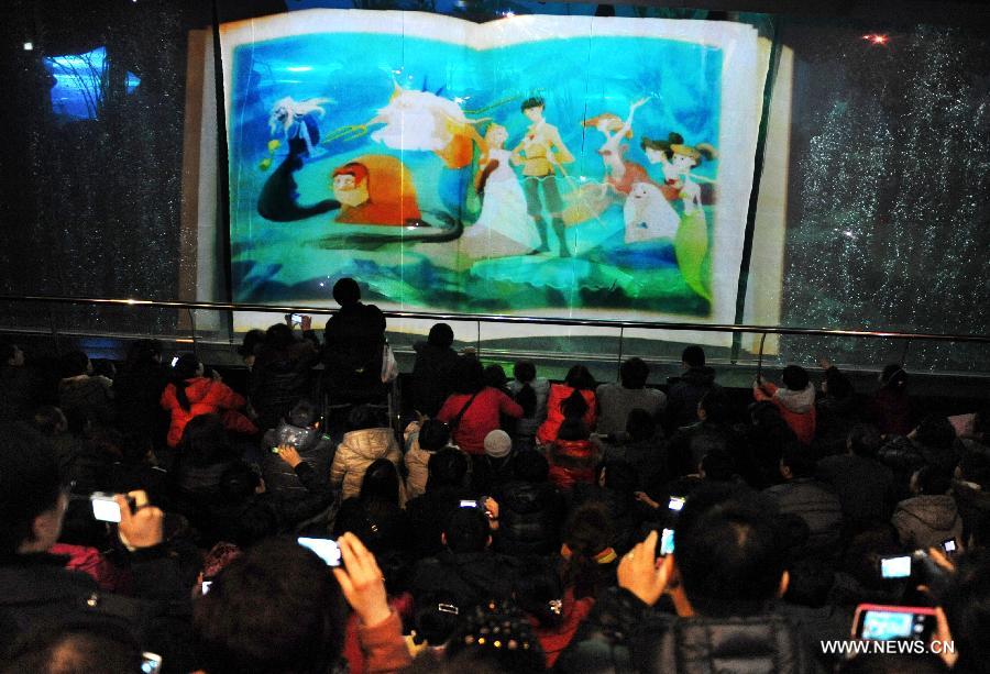 Spectators watch an underwater performance at Qingdao Underwater World in Qingdao, east China's Shandong Province, Feb. 15, 2013. During the Spring Festival holidays, an underwater performance telling the story of a mermaid and a prince attracted many visitors in Qingdao. Visual, audio and electronical technologies were applied to the performance. (Xinhua/Li Ziheng) 