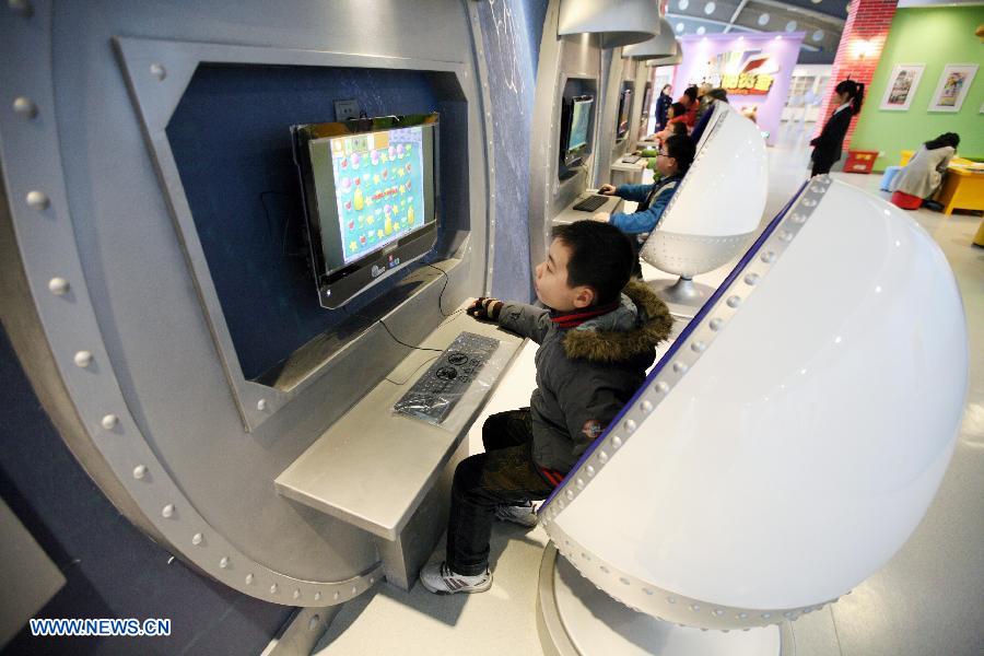 A boy tries an interactive device at a cartoon experience center in Nanjing Science and Technology Museum in Nanjing, capital of east China's Jiangsu Province, Feb. 14, 2013. A cartoon experience center covering an area of 2700 square meters started its test operation on Thursday, offering a place for fans to know about the cartoon culture and industry. (Xinhua) 
