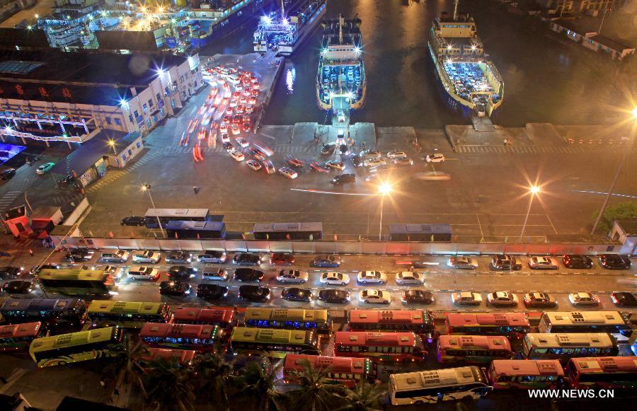 Vehicles which were detained by a heavy fog leave a port in Haikou, capital of south China's Hainan Province, late Feb. 15, 2013. A total of 46,000 passengers and 8,700 vehicles have left the Port of Haikou from 8:00 p.m. Friday to 8:00 a.m. Saturday, after being detained by a heavy fog that disrupted the waterway traffic across the Qiongzhou Strait. (Photo/ Xinhua) 