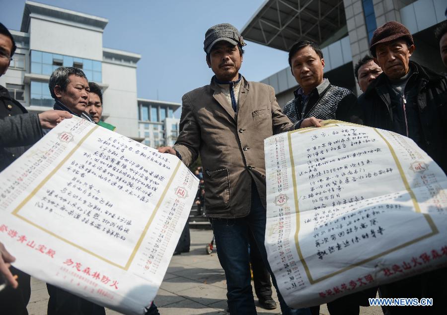Chen Jiahe (C), a job seeker from east China's Jiangxi Province, demonstrates poems written by him at a job fair in Yiwu, east China's Zhejiang Province, Feb. 16, 2013. China has begun to see a resurgence in the number of both employers and job seekers after the week-long Spring Festival holiday. (Xinhua/Han Chuanhao)