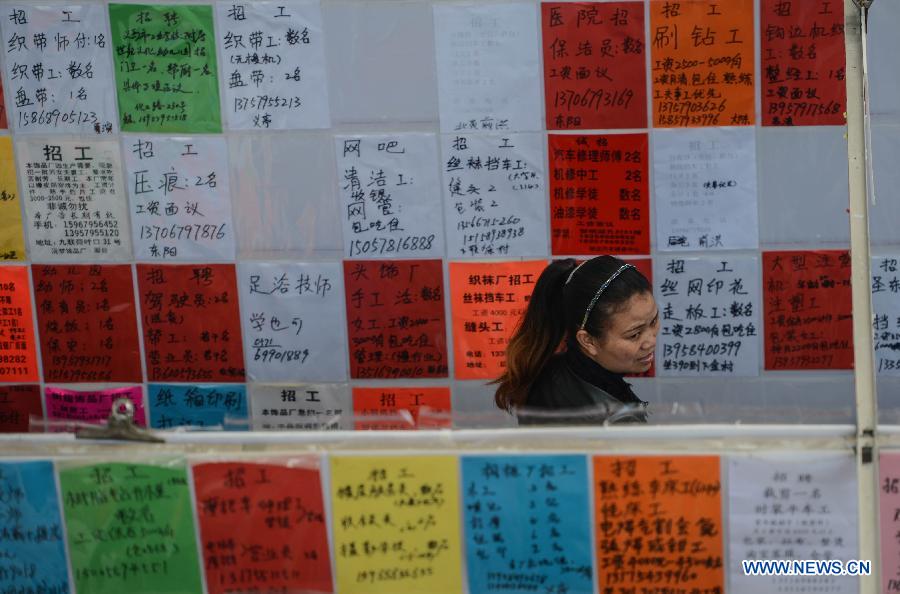 A woman looks for career opportunities at a job fair in Yiwu, east China's Zhejiang Province, Feb. 16, 2013. China has begun to see a resurgence in the number of both employers and job seekers after the week-long Spring Festival holiday. (Xinhua/Han Chuanhao)