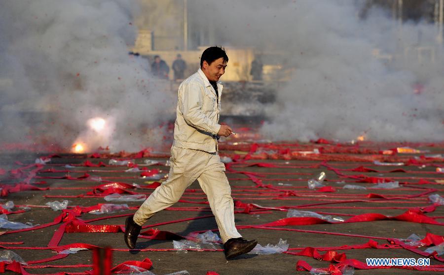 A staff member of an enterprise sets off firecrackers in Shenyang, capital of northeast China's Liaoning Province, Feb. 16, 2013. Saturday marks the first working day after the one-week Spring Festival break which started on Feb. 9. Setting off firecrackers on this day is a traditional custom for businessmen to pray for a booming year. (Xinhua/Tian Weitao)