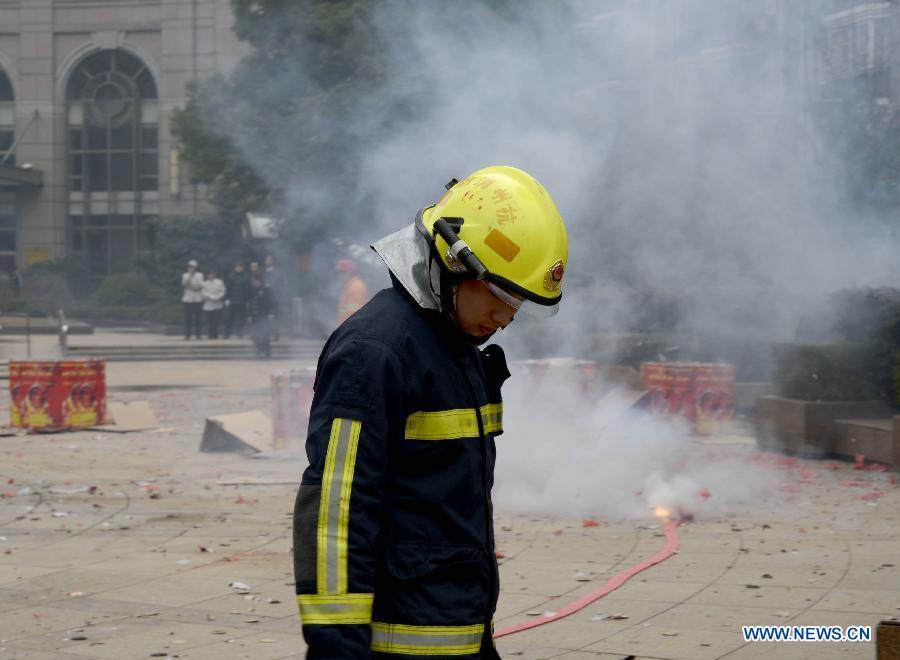A firefighter supervises as people set off firecrackers at Zhongda Square in Hangzhou, capital of east China's Zhejiang Province, Feb. 16, 2013. Saturday marks the first working day after the one-week Spring Festival break which started on Feb. 9. Setting off firecrackers on this day is a traditional custom to pray for a booming year. (Xinhua/Shi Jianxue)