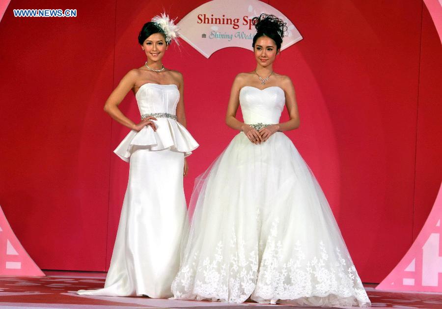 Two models present creations at a wedding dress show during the 70th Valentine's Wedding Service and Banquet Expo in south China's Hong Kong, Feb. 16, 2013. The three-day Expo kicked off on Friday at Hong Kong Convention and Exhibition Center. (Xinhua/Jin Yi) 