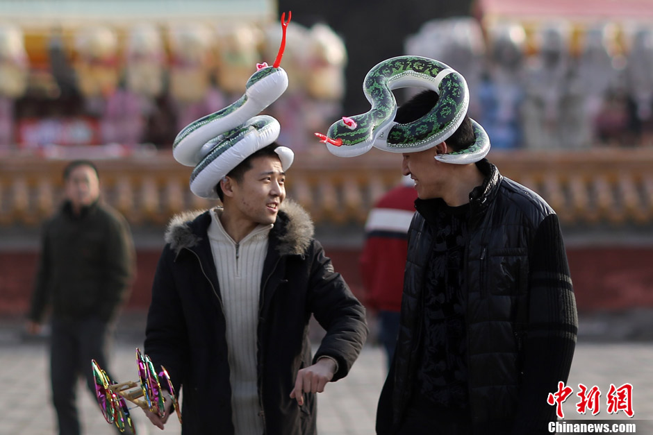 Snake element in the Year of Snake: Two men return home with souvenirs bought at temple fair in Ditan Park, Beijing, Feb. 12, 2013. (Chinanews.com/Sheng Jianan) 