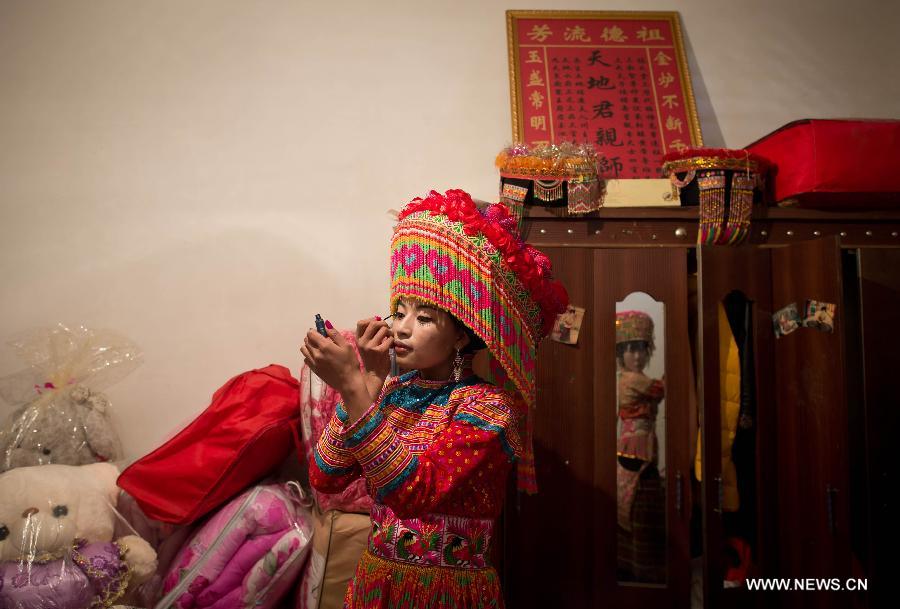 Zhang Lu, a bride of the Lisu ethnic group, dresses up herself before her wedding in Xinyu Village of Dechang County, southwest China's Sichuan Province, Feb. 15, 2013. Dechang's Lisu people live in family- or clan-based villages most of which locates on river valley slopes of around 1,500 to 3,000 meters above the sea level. They still practice a wedding tradition that has uncommon conventions including bridal face-shaving, outdoor wedding banquet and overnight group dance. (Xinhua/Jiang Hongjing) 