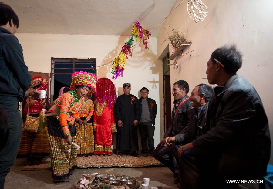 Family members of a Lisu wedding couple attend a bow ceremony which officially makes the couple husband and wife in Xinyu Village of Dechang County, southwest China's Sichuan Province, Feb. 15, 2013. Dechang's Lisu people live in family- or clan-based villages most of which locates on river valley slopes of around 1,500 to 3,000 meters above the sea level. They still practice a wedding tradition that has uncommon conventions including bridal face-shaving, outdoor wedding banquet and overnight group dance. (Xinhua/Jiang Hongjing) 