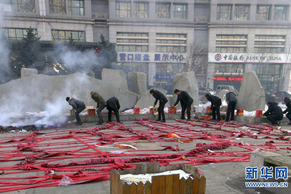 People ignite fireworks at a plaza in Shenyang, northeastern China's Liaoning province, Saturday morning, February 16, 2013. Firework sprees are staged in many places around China on Saturday morning, the first workday after this year's Spring Festival holidays. Many Chinese businessmen pray this way for a properous new year, but such activities have also been blamed for burdening cleaning workers and worsening air pullution. （Photo/Xinhua）