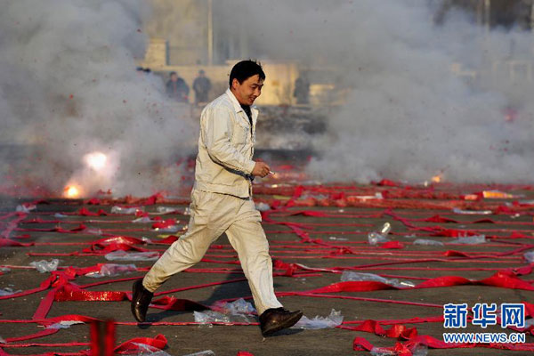 A man escapes after igniting fireworks in front of a factory in Shenyang, northeastern China's Liaoning province, Saturday morning, February 16, 2013. Firework sprees are staged in many places around China on Saturday morning, the first workday after this year's Spring Festival holidays. Many Chinese businessmen pray this way for a properous new year, but such activities have also been blamed for burdening cleaning workers and worsening air pullution. (Photo/Xinhua) 