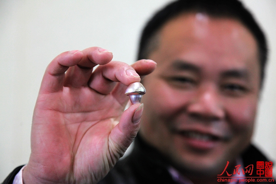 Fu shows his collection: a mushroom-shaped pearl.(People's Daily Online/ Wang Chu) 