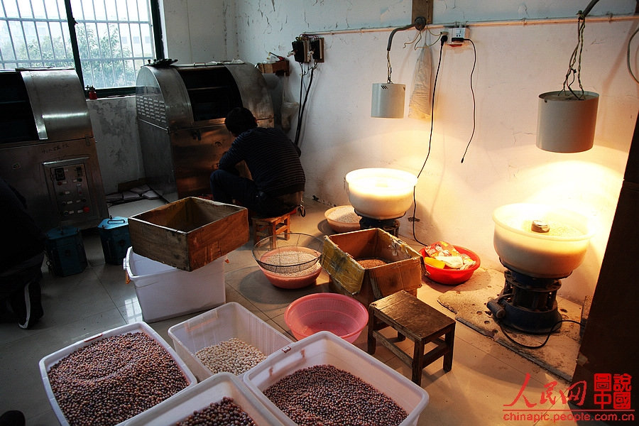 A worker polishes irregular shaped freshwater pearls to make them prefect round. (People's Daily Online/ Wang Chu) 