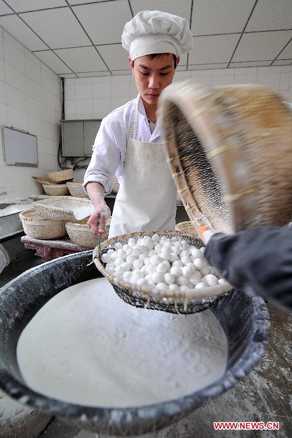A cook makes Yuanxiao, glutinous rice flour dumpling with sweetened stuffing, at a food shop in Taiyuan, capital of north China's Shanxi Province, Feb. 16, 2013. Yuanxiao is a traditional festive food for the Lantern Festival, which falls on Feb. 24 this year. (Xinhua/Zhan Yan) 