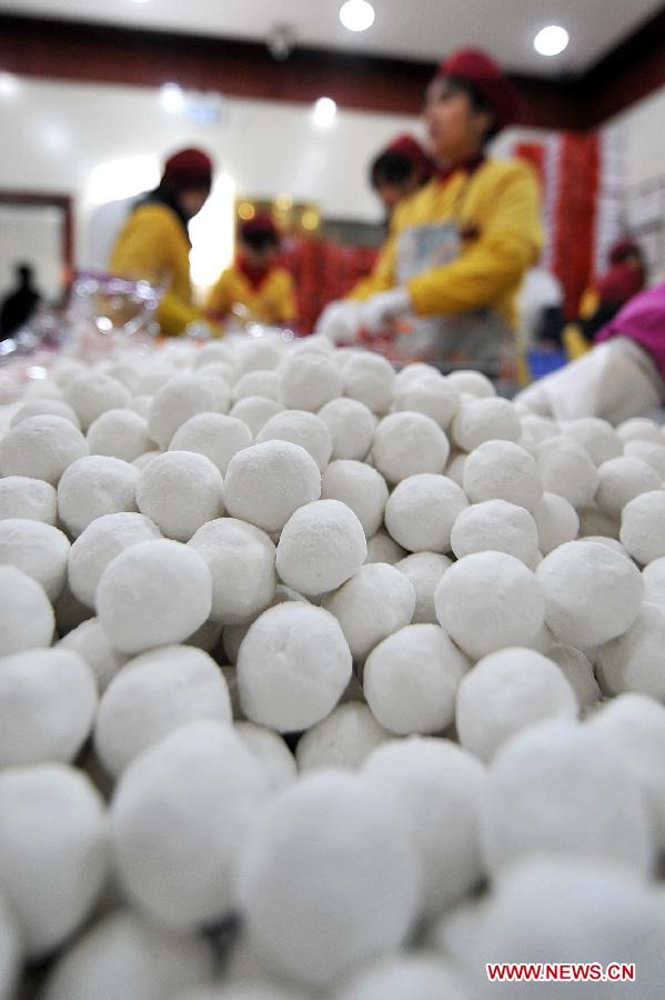 Staff members pack Yuanxiao, glutinous rice flour dumpling with sweetened stuffing, at a food shop in Taiyuan, capital of north China's Shanxi Province, Feb. 16, 2013. Yuanxiao is a traditional festive food for the Lantern Festival, which falls on Feb. 24 this year. (Xinhua/Zhan Yan)  