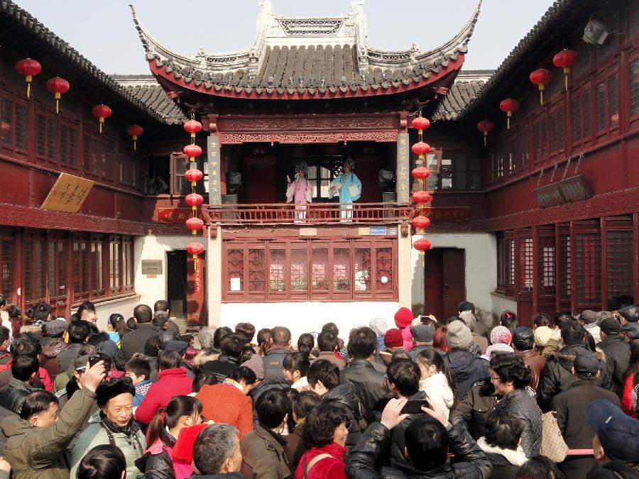 Tourists watch the opera performance at Shantang Street, a scenic spot in Suzhou, east China's Jiangsu Province, Feb. 10, 2013. The number of tourists during the week-long Spring Festival holiday topped 203 million across the country, up 15.1 percent from the same period last year, according to the latest statistics by the National Tourism Administration. The Spring Festival, or the Chinese Lunar New Year, fell on Feb. 10 this year. (Xinhua/Wang Jiankang)